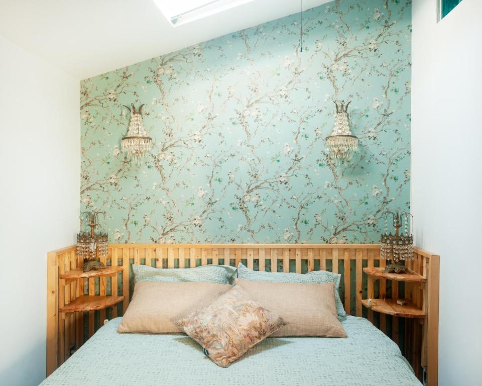 a bedroom with a bed with a floral wallpaper at Chapim Azul Studio in Cabrela