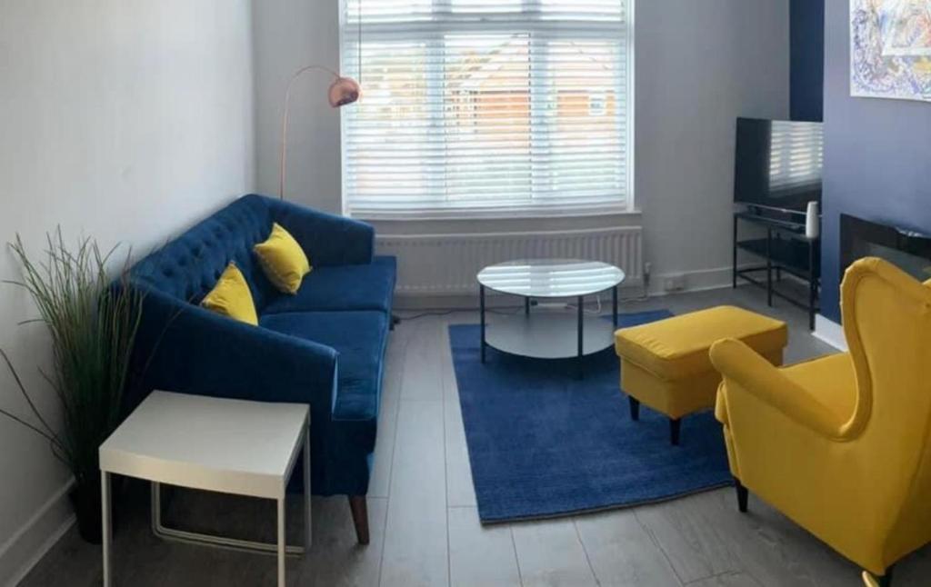 a living room with a blue couch and yellow chairs at Shotley Bridge - Large Stylish 3 Bedroom Apartment in Consett