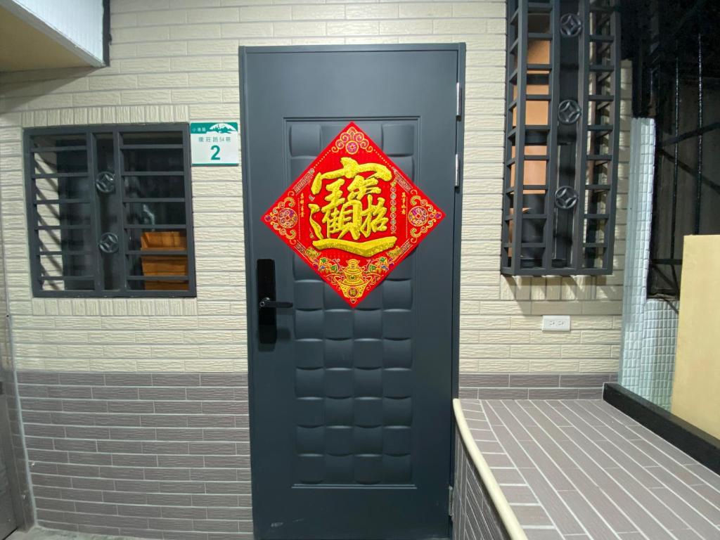 a door with a red sign on it at 康莊背包旅宿 上下舖背包床位4人&6人房&雙人床房-14人包棟-預訂請來電確認 in Ch'ing-tao-ts'un