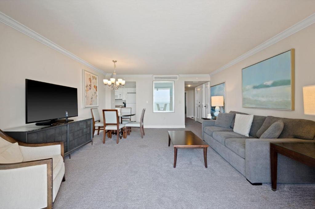 a living room with a couch and a dining room at Marco Beach Ocean Suites in Marco Island