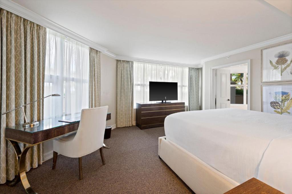 a large white bedroom with a desk and a bed at Marco Beach Ocean Suites in Marco Island