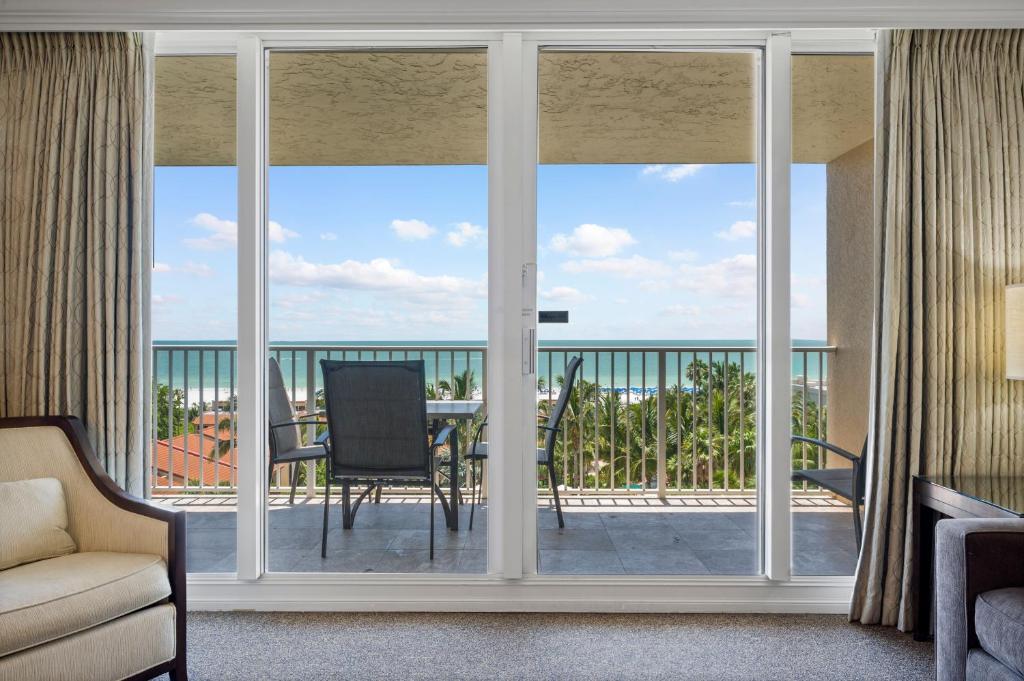 ein Wohnzimmer mit Glasschiebetüren und Meerblick in der Unterkunft Marco Beach Ocean Suites in Marco Island