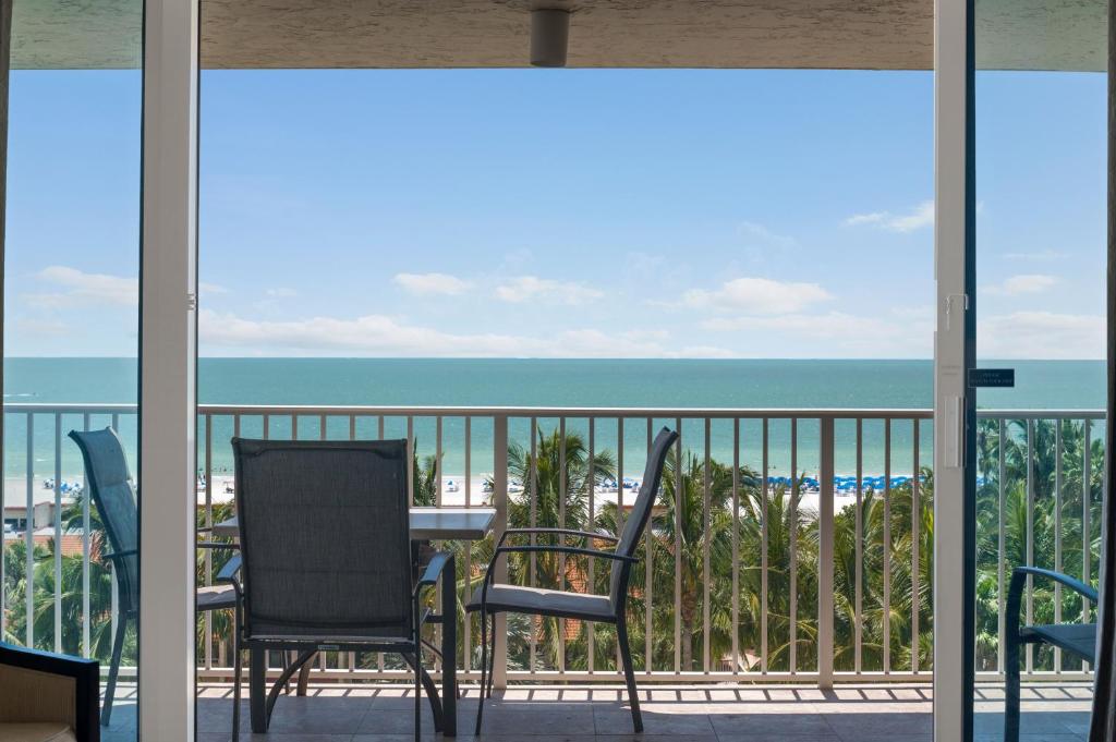 a balcony with chairs and a table and the ocean at Marco Beach Ocean Suites in Marco Island