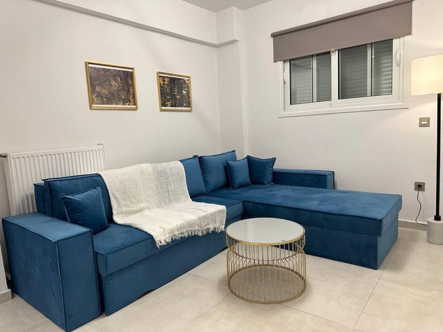 a living room with a blue couch and a table at Oculus Kolonaki Apt in Athens
