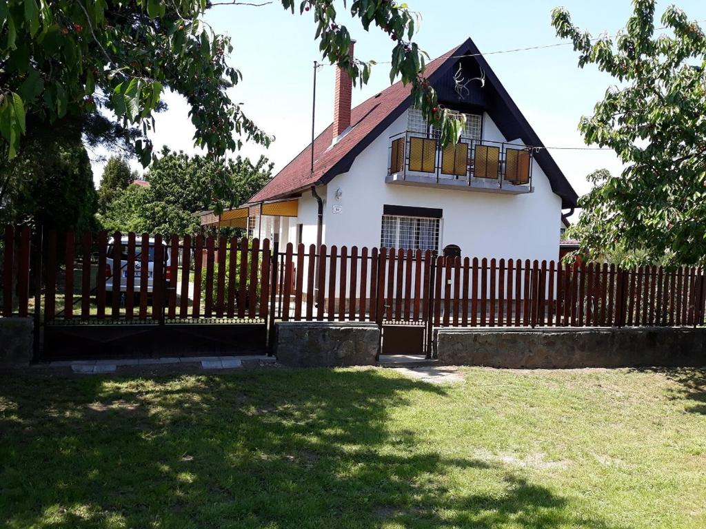 Szilva Apartman في Fertőhomok: حاجز خشبي أمام المنزل