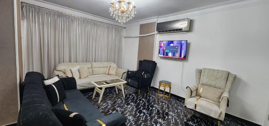 een woonkamer met een bank en 2 stoelen bij Unique Apartment in Sheraton Heliopolis in Caïro