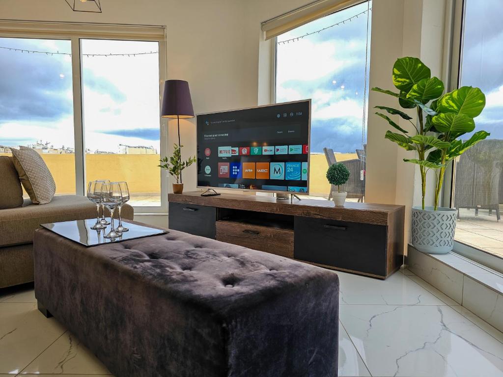 a living room with a large tv and a couch at MIVE Luxury Sea View Penthouse in Il-Gżira