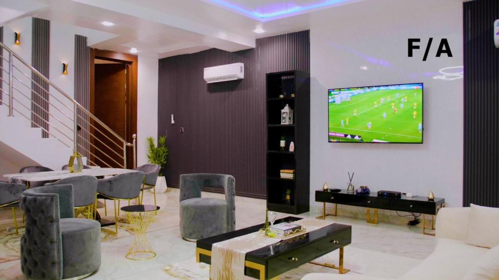 uma sala de estar com uma televisão na parede em Favourite Luxury Apartment em Ikeja