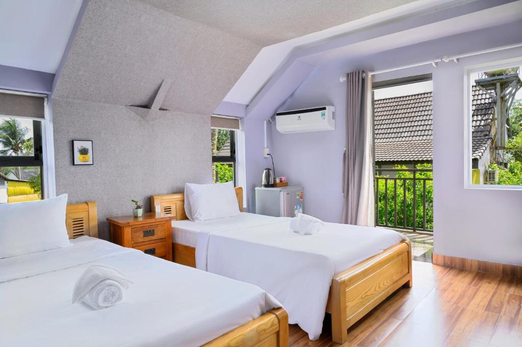 1 dormitorio con 2 camas y ventana en Lilac Cottage Homestay en Phu Quoc
