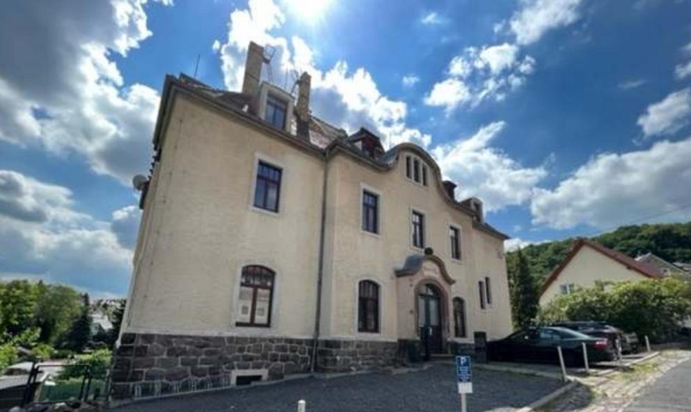 Un gran edificio blanco al costado de una calle. en Ausblick Freital, en Freital