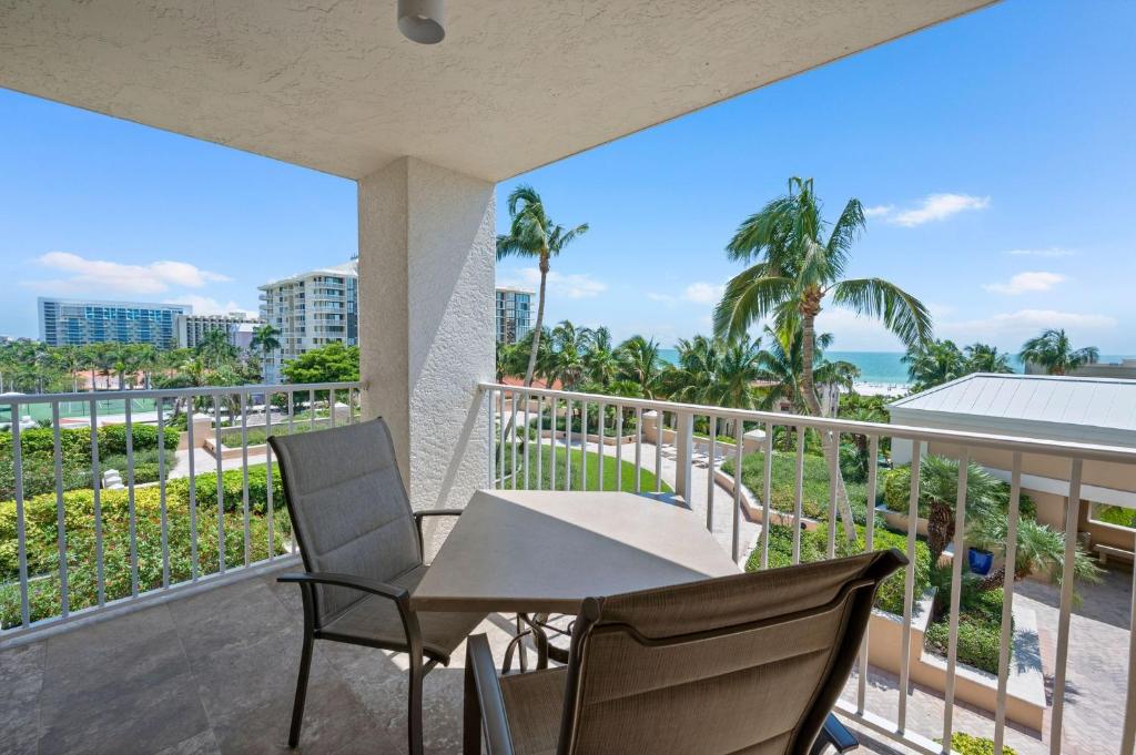 a balcony with a table and chairs and the ocean at Marco Beach Ocean Suites in Marco Island