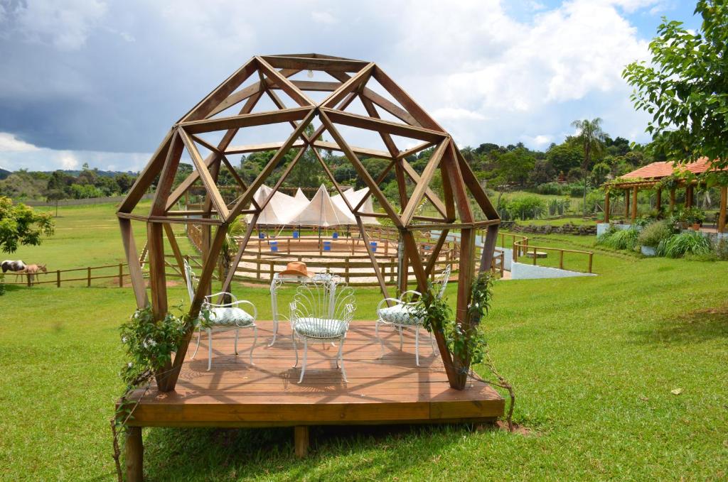 a wooden gazebo with a table in the grass at Estância EK in Franca