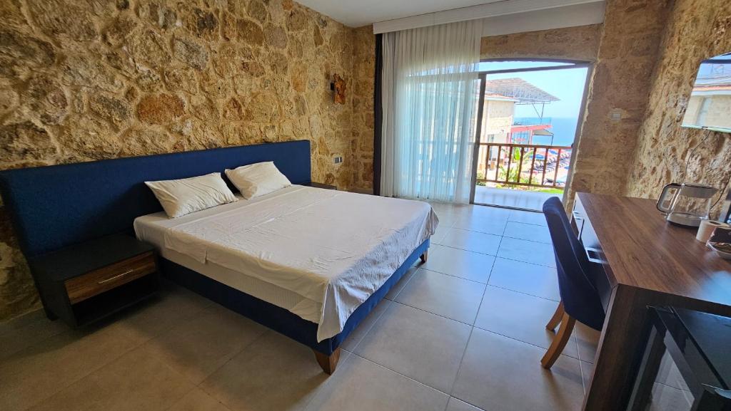 um quarto com uma cama azul, uma mesa e uma janela em BURHAN'S HOTEL em Rizokarpaso