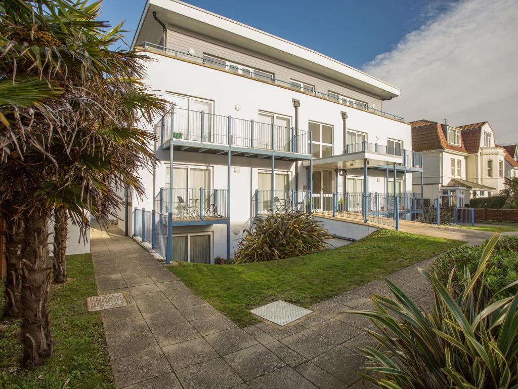 a large white building with a garden in front of it at 1 Blue Waters in Bournemouth