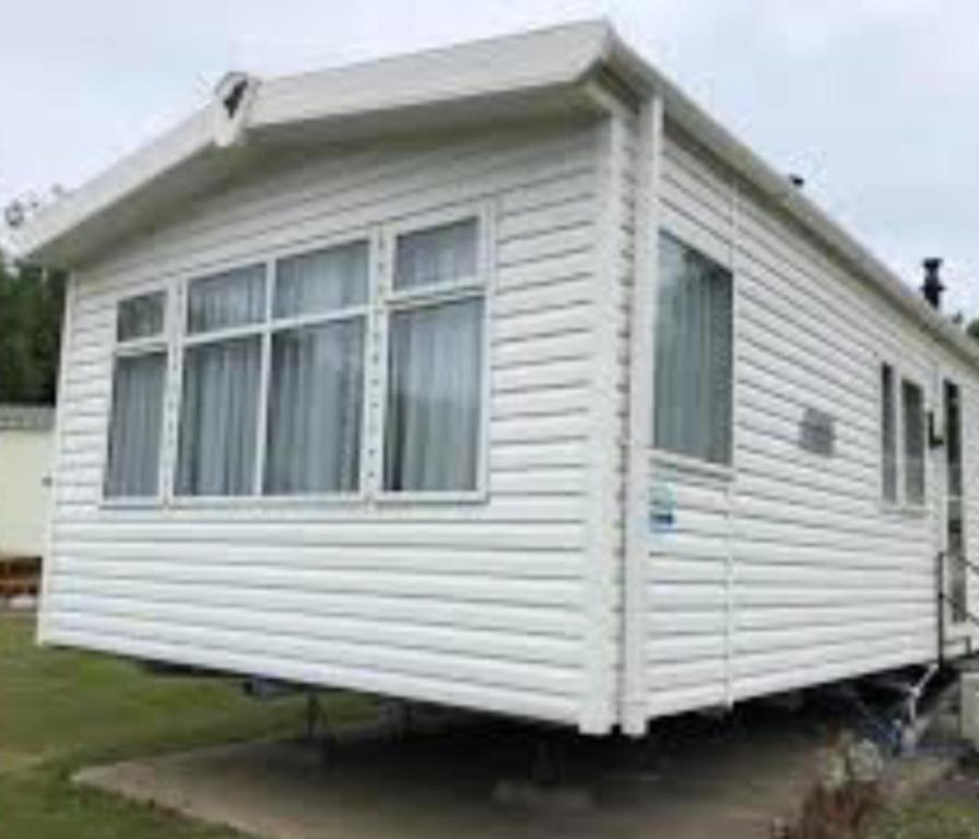 a white house sitting on top of a yard at Caravan 4 - Cambrian Coast Caravan Park in Borth