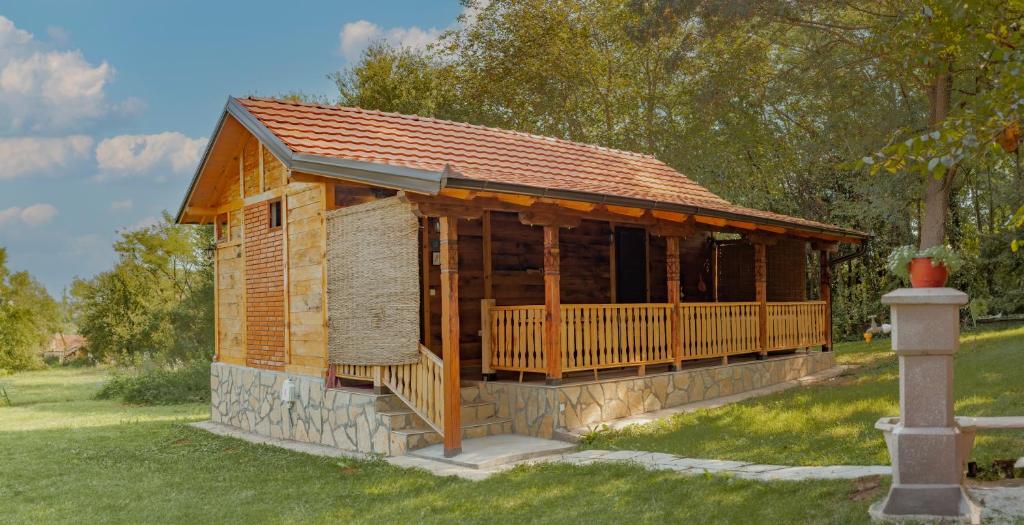 a log cabin with a porch and a roof at Gruzanski horizonti std1 in Knić