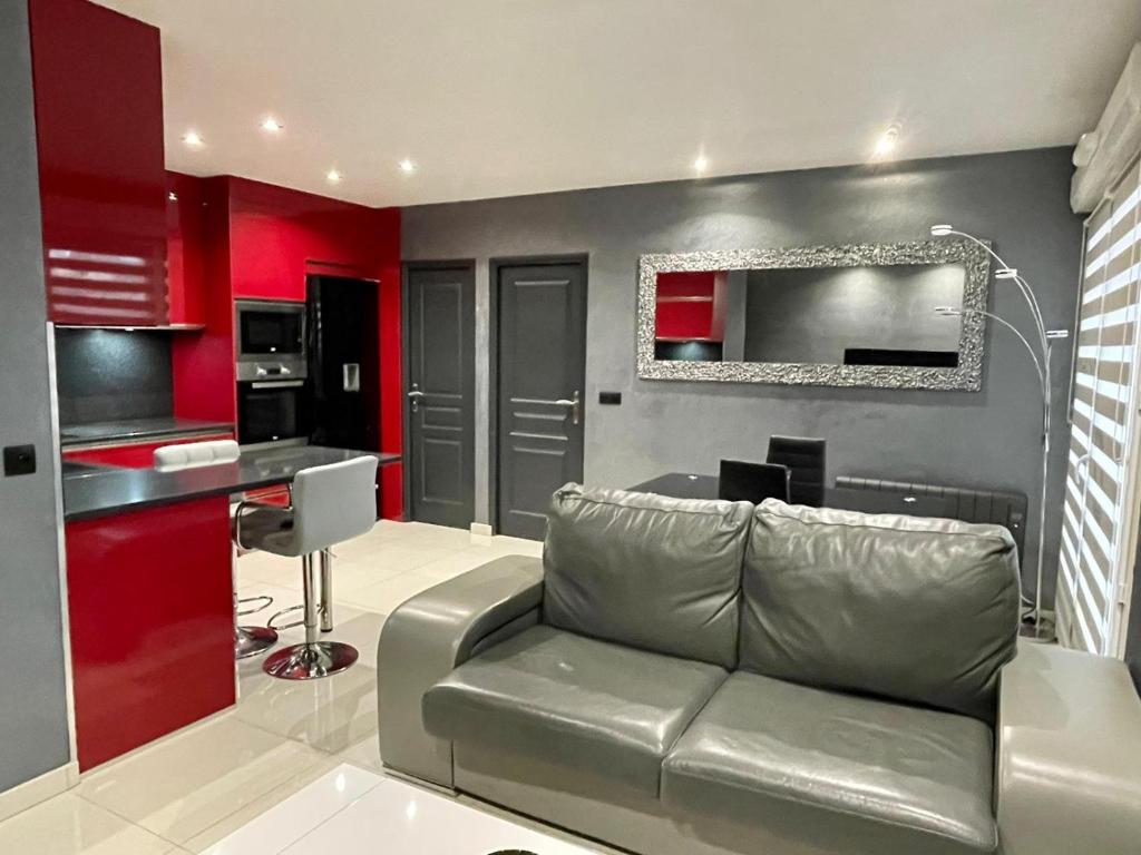 - un salon avec un canapé et des murs rouges dans l'établissement Ambre&Tiago, à Vaires-sur-Marne