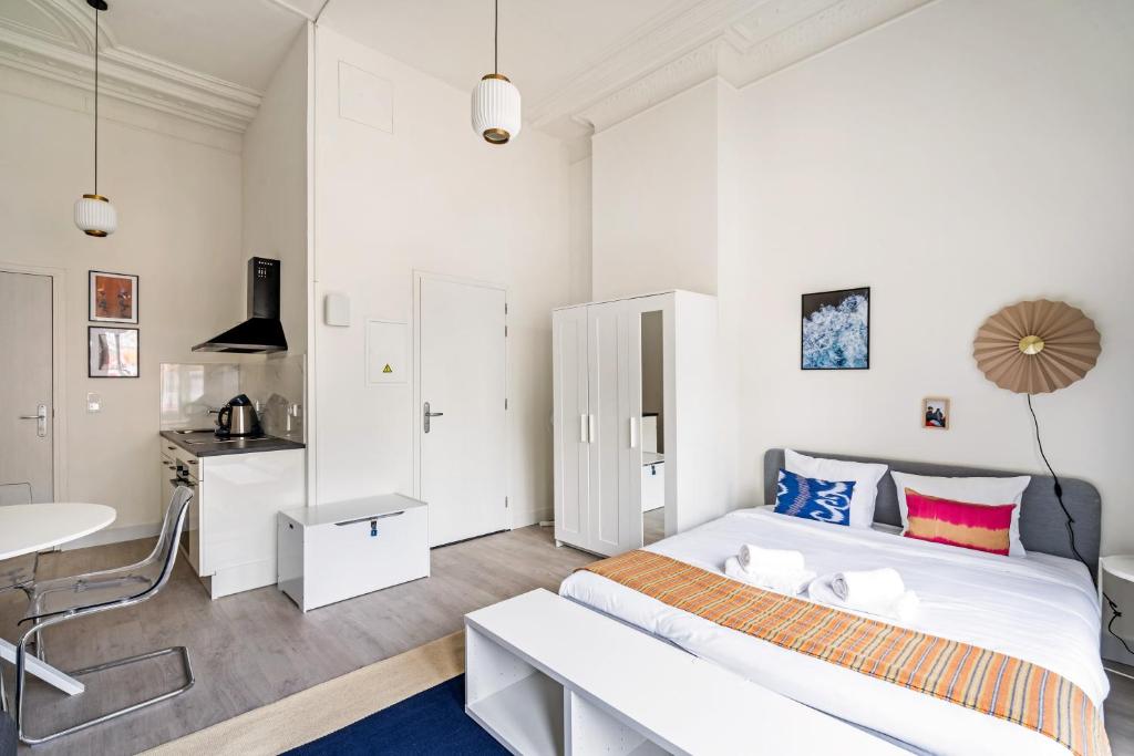 a white bedroom with a bed and a desk at Smartflats - the City Antwerp in Antwerp