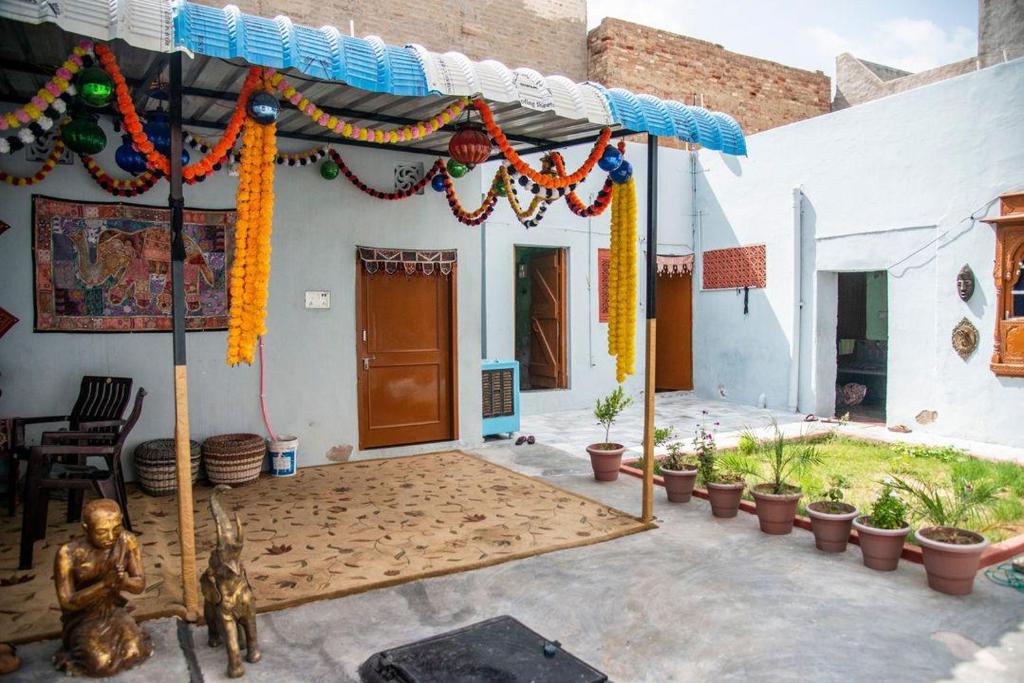 a house with a tent with a statue in the courtyard at Little prince guest house & homestay in Bikaner