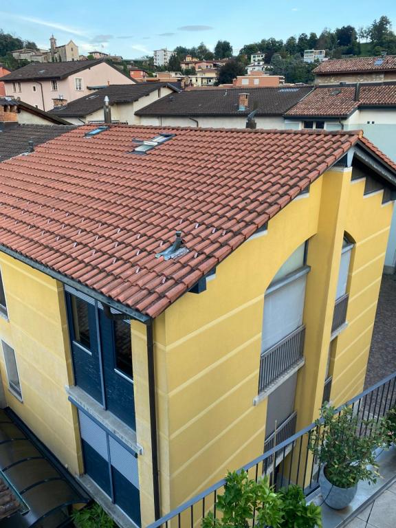 uma casa amarela com um telhado vermelho em Yellow House Guest House em Mendrisio