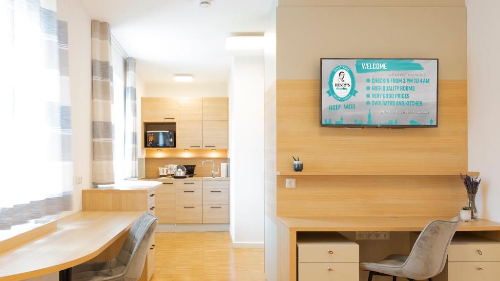 a kitchen with a table and a tv on a wall at Henrys Sleeping am Augsburger Eiskanal in Augsburg