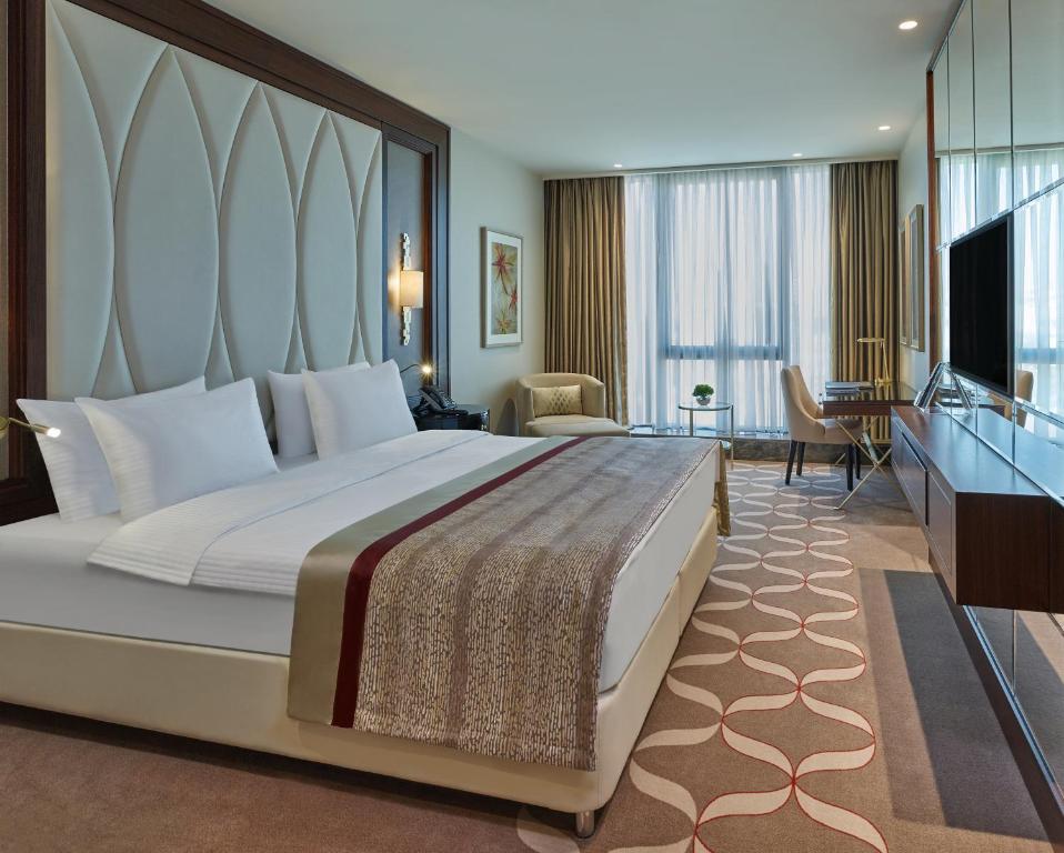a hotel room with a large bed and a television at Elite World Grand Istanbul Basın Ekspres in Istanbul
