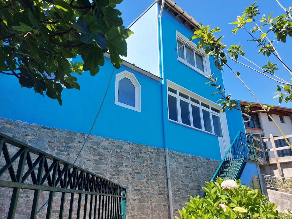 ein blaues Haus mit einer Steinmauer in der Unterkunft Villa Mercedes in Luarca