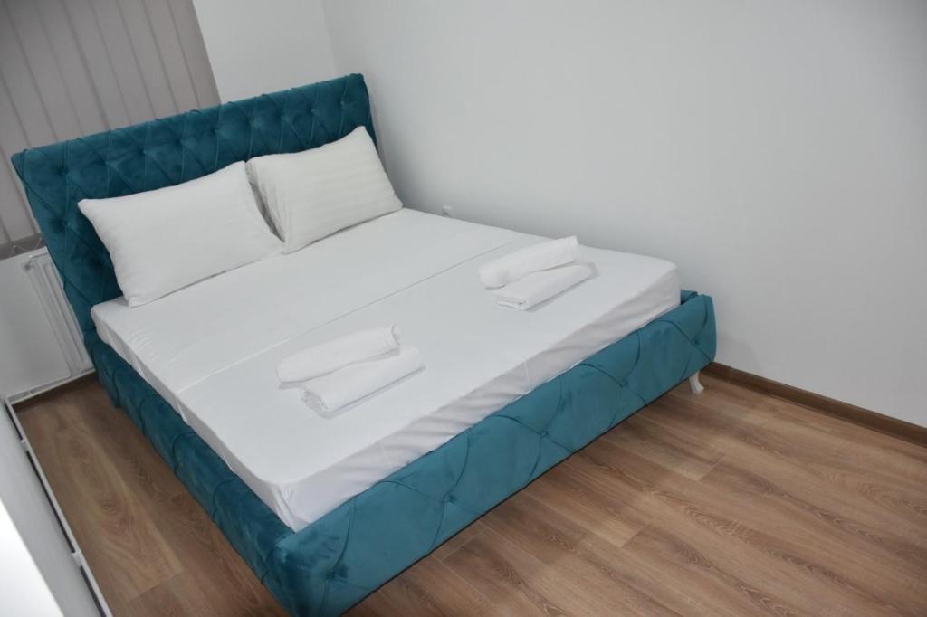 Ce lit se trouve dans un dortoir blanc et bleu. dans l'établissement Bella apartmani, à Požarevac