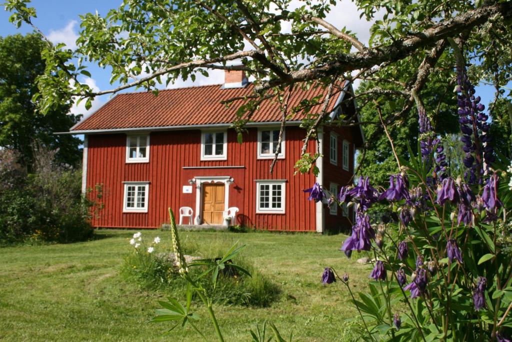 a red house with flowers in front of it at Brännsjötorp in Målilla