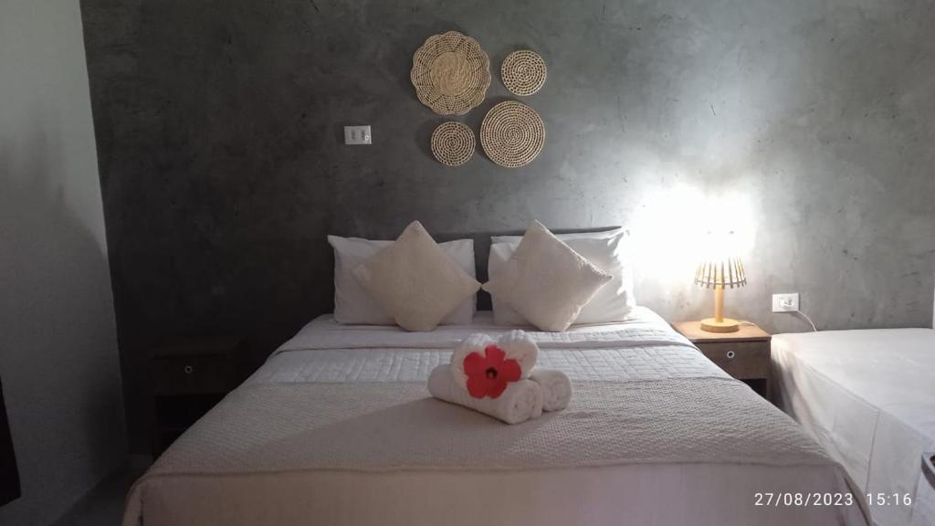 un dormitorio con una cama con una flor de peluche en Casa Flôr, en Fernando de Noronha
