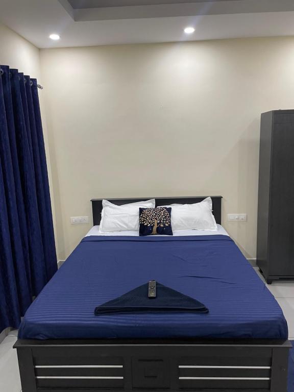 um quarto com uma cama com uma colcha azul em Uniro Rooms & Packages em Cochin
