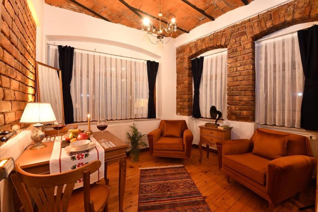 uma sala de estar com uma parede de tijolos em Historical Flat @Taksim no1 em Istambul