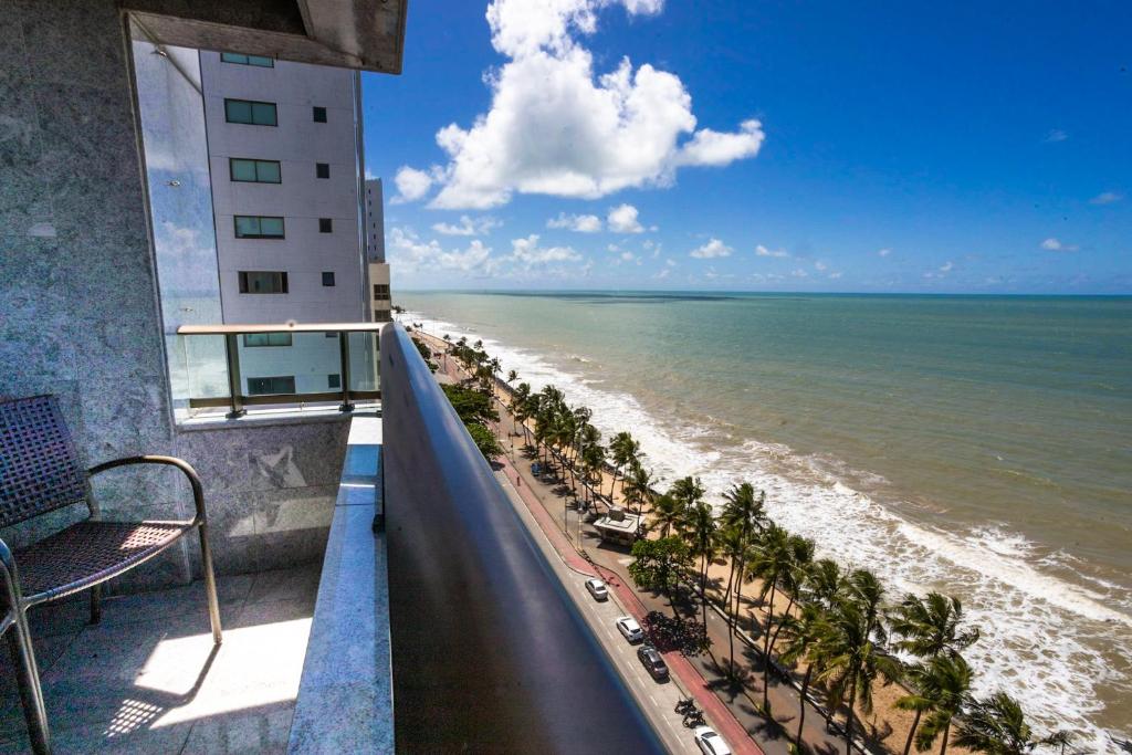 un balcone con vista sulla spiaggia e su un edificio di Nobile Residences Maria Frazão a Recife