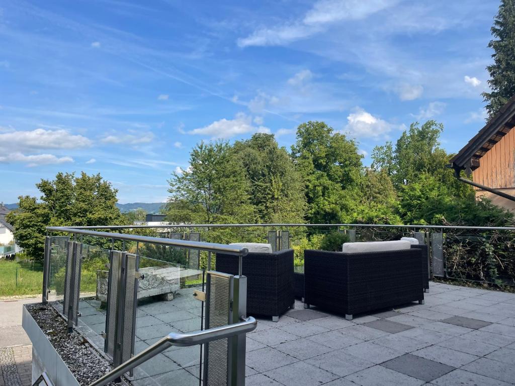 a balcony with two chairs on a patio at Fewo BOHO 110 qm mit Bergblick 3 min Bahnhof in Laufen