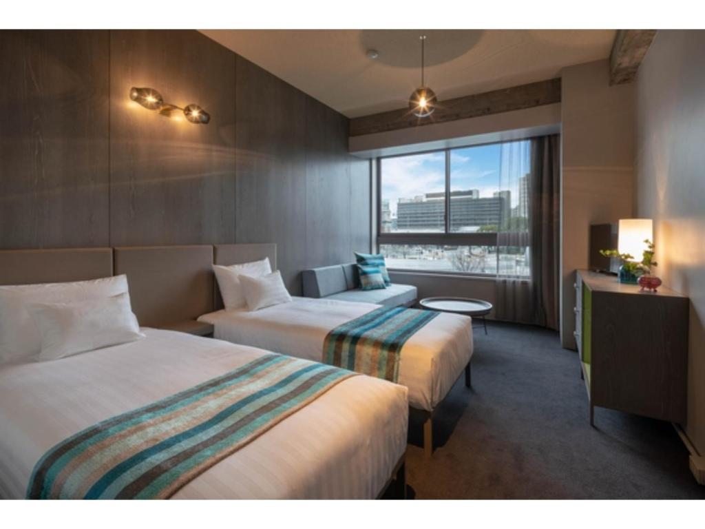 Cette chambre comprend 2 lits et une fenêtre. dans l'établissement THE BOLY OSAKA - Vacation STAY 52787v, à Osaka