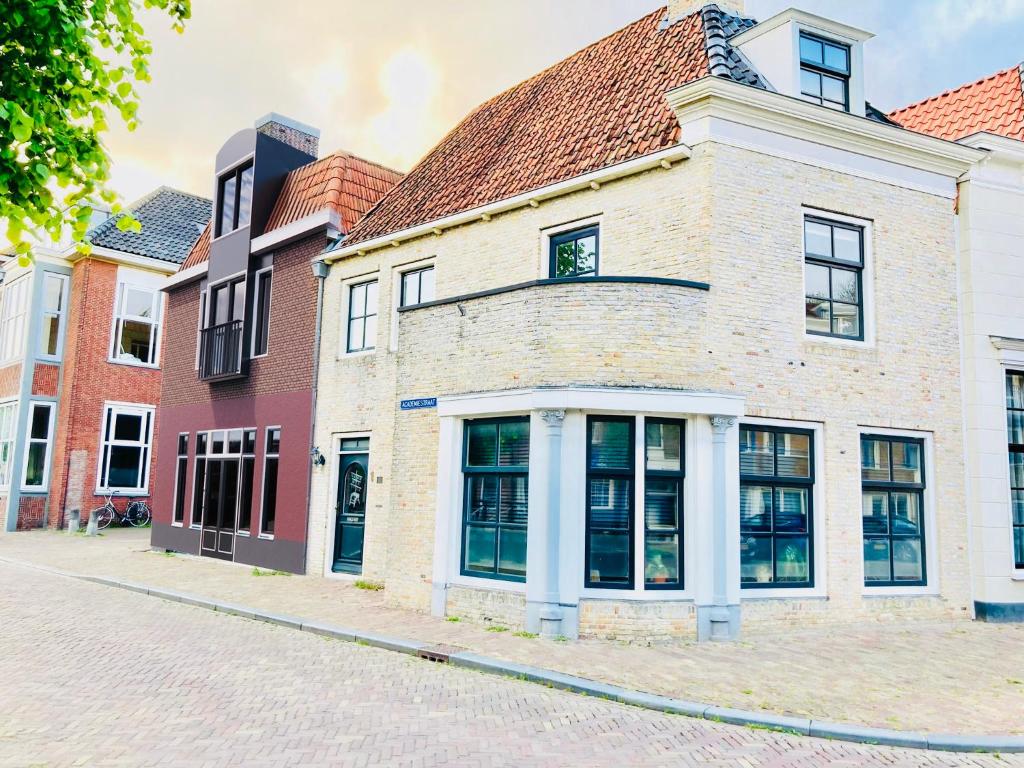 een oud bakstenen gebouw in een stadsstraat bij Stadshotel DE ACADEMIE in Franeker