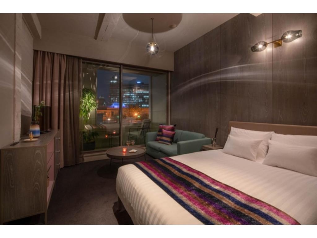 sypialnia z łóżkiem, krzesłem i oknem w obiekcie THE BOLY OSAKA - Vacation STAY 52783v w Osace