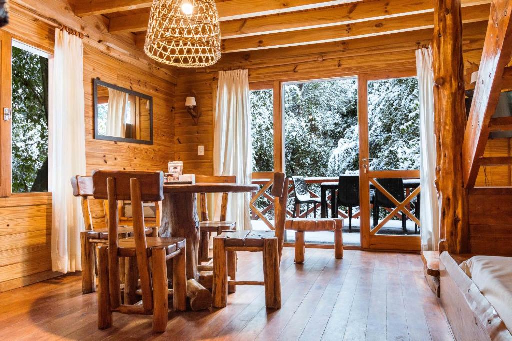 comedor con mesa y sillas en una cabaña en BOG Torres del Bayo en Villa La Angostura