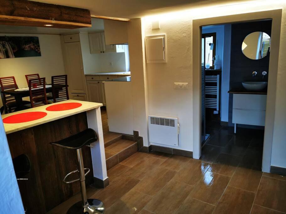 a kitchen and living room with a counter and a stool at Joli appartement au cœur du village in Orsières