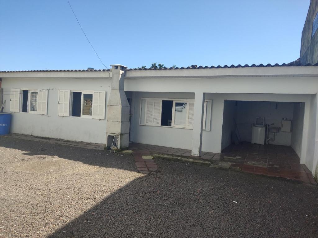 une maison blanche avec un garage et un bâtiment dans l'établissement Residencial Ramos, à Torres
