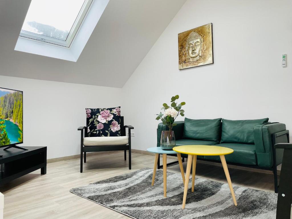 ein Wohnzimmer mit einem grünen Sofa und einem gelben Tisch in der Unterkunft Ferienwohnung in Schönbrunn in Schönbrunn