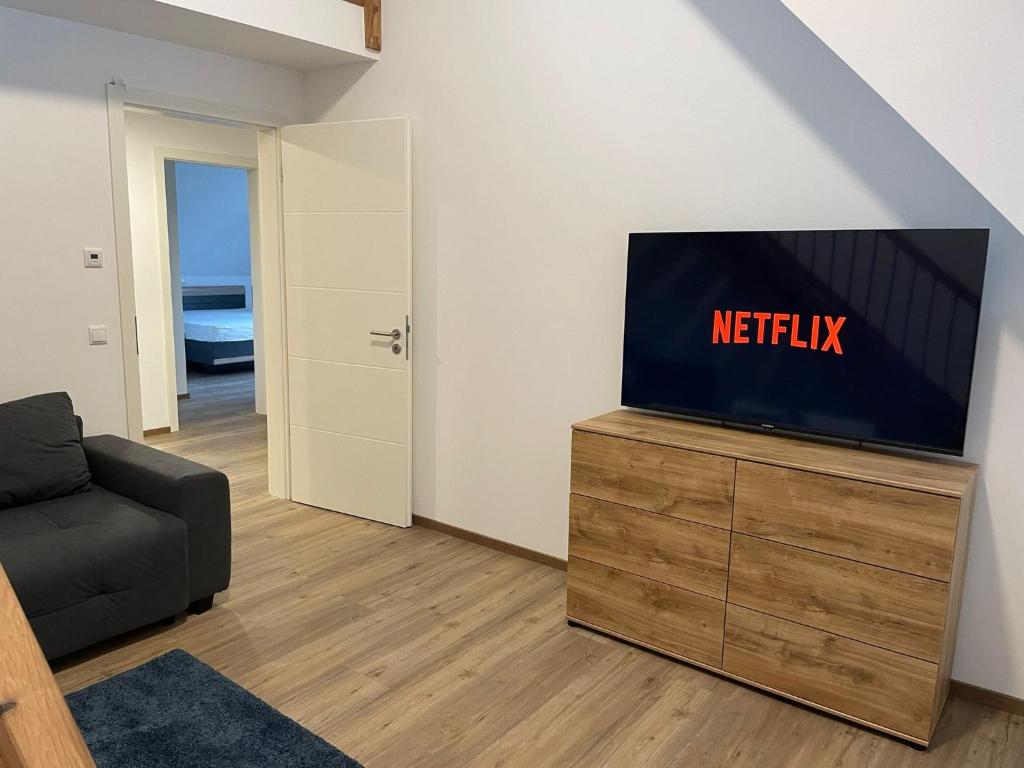 a living room with a flat screen tv on a dresser at Backstage Oberaudorf in Oberaudorf