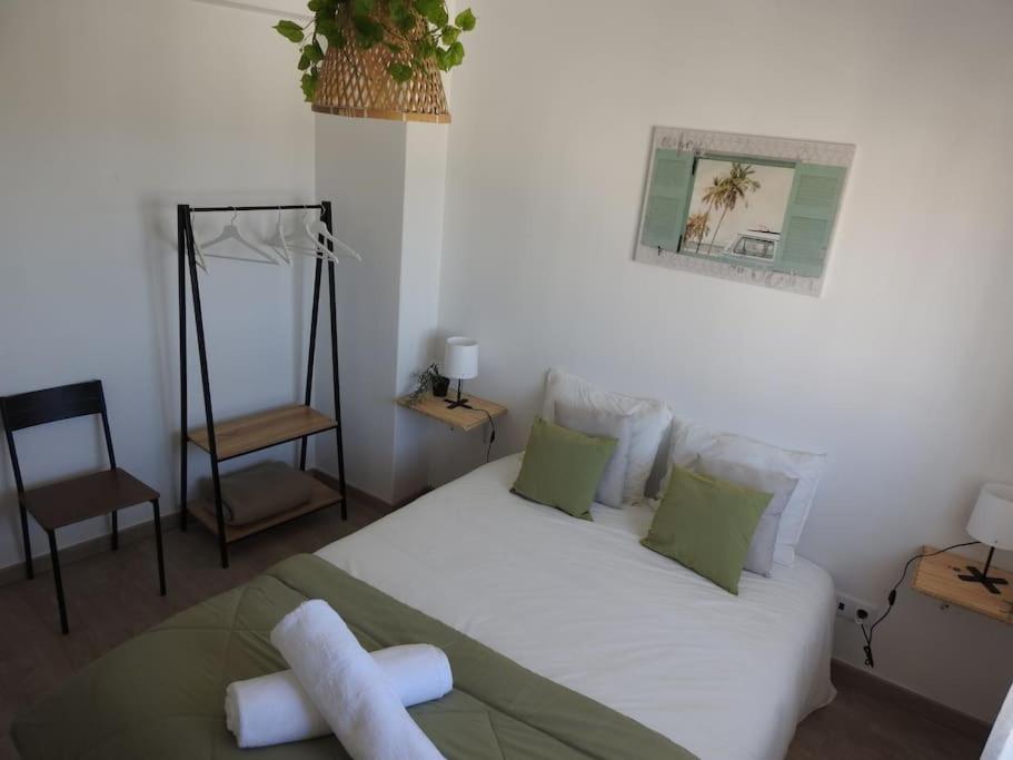 Un dormitorio con una gran cama blanca con almohadas verdes. en Seacastle Residence Peniche, en Atouguia da Baleia