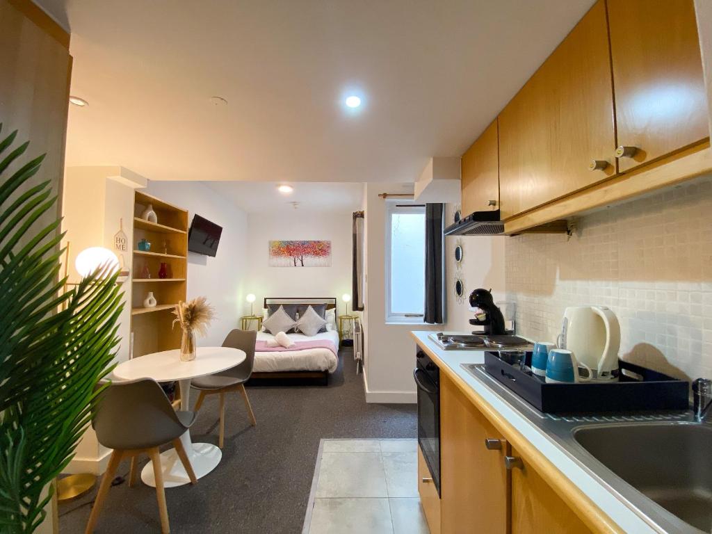 een keuken en een woonkamer met een bed bij Modern Studios Close To Hyde Park in Londen