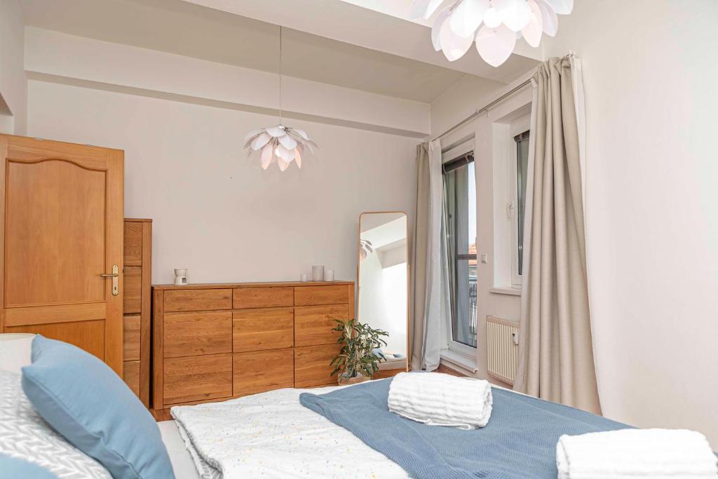 a bedroom with a bed and a dresser and a mirror at Castle View Apartment in Bratislava