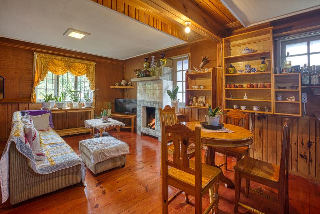 a living room with a table and a fireplace at Gina’s Homes in Sagada