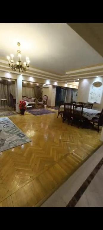 a living room with wooden floors and a chandelier at VIP Apartment حامعه الدول العربيه Mohandsein in Cairo