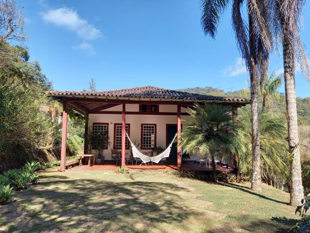 a small house with a hammock in front of it at Sítio de Lazer com Piscina em Ouro Preto in Ouro Preto
