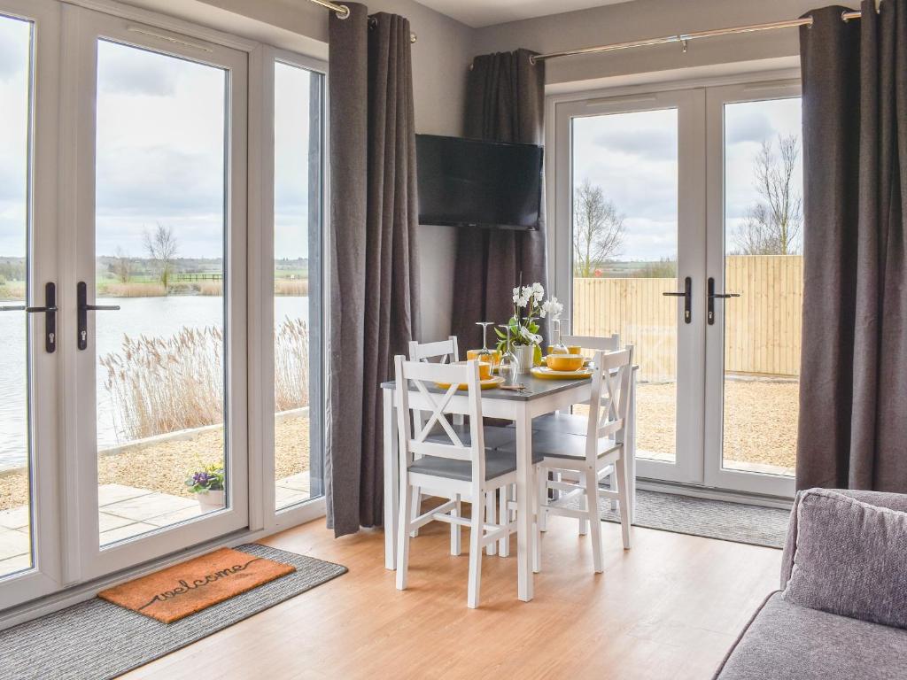 a dining room with a table and chairs and sliding glass doors at Hare Lodge - Uk30604 in Pidley