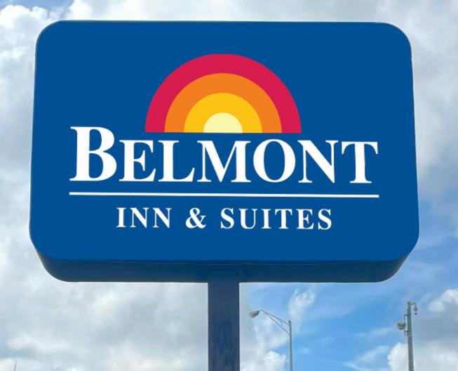 una señal azul para un cartel para una posada y suites arcoiris en Belmont Inn & Suites, en Florida City